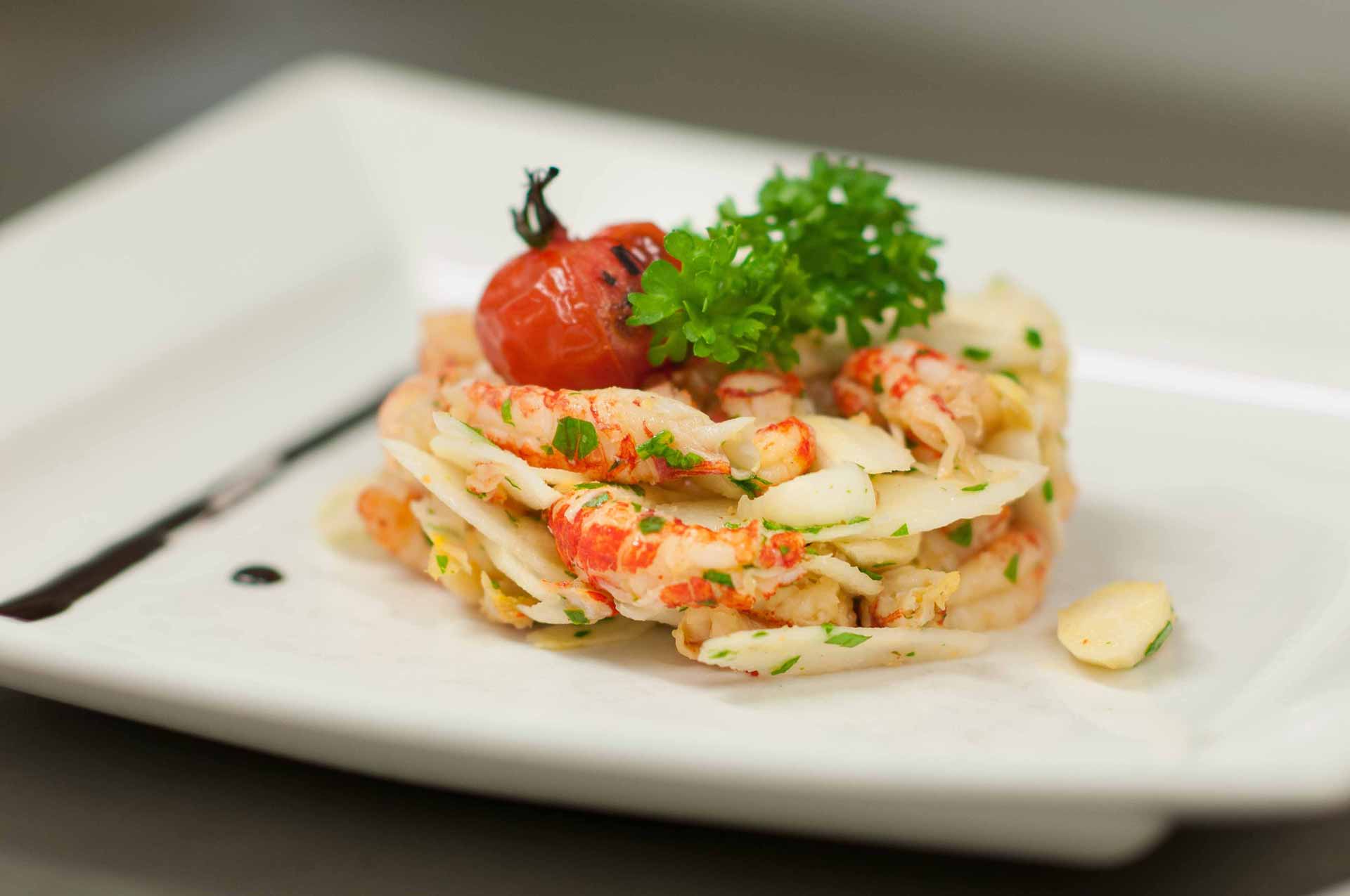 Fein angerichtete Vorspeise mit Garnelen und Tomate