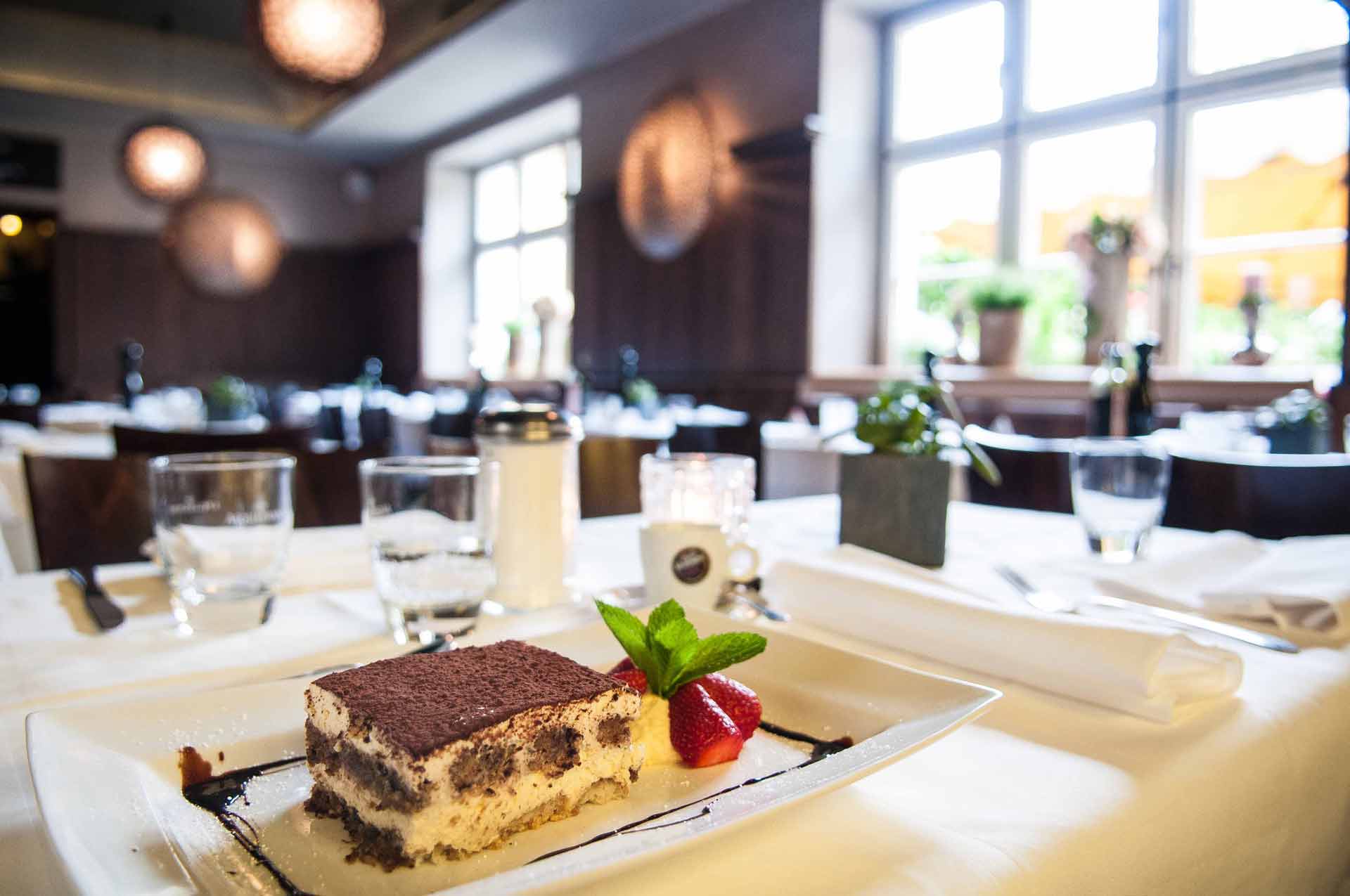 Tiramisu mit Erdbeeren, im Hintergrund der Gastraum
